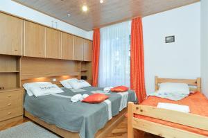 sypialnia z 2 łóżkami pojedynczymi i pomarańczowymi zasłonami w obiekcie Apartments Jasna 1128 w Fažanie