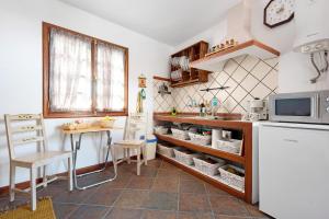 a kitchen with a refrigerator and a table and a microwave at La Casita Canaria in Los Silos
