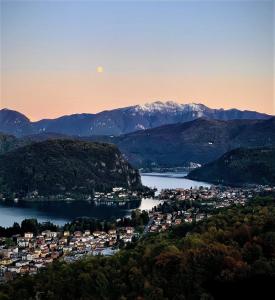 una città su un lago con la luna nel cielo di Hotel Ristorante Stampa a Lavena Ponte Tresa