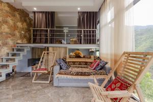 a bedroom with a bunk bed and two chairs at Vaio Resort in Keda in K'eda