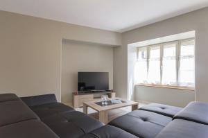 a living room with two couches and a tv at Chez Germaine in Saint-Romain