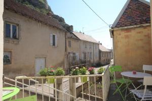 a balcony with a table and flowers on a building at Chez Germaine in Saint-Romain