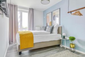 Un dormitorio con una cama grande con una manta amarilla. en limehome Garching bei München en Garching bei München