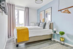 a bedroom with a large bed with a yellow blanket on it at Limehome Garching bei München in Garching bei München +29 photos