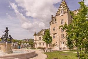 un edificio con una estatua frente a una fuente en Maison Picard, en Saint-Romain