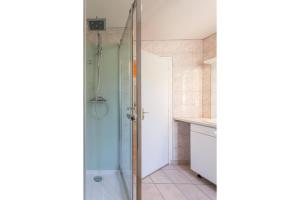 una ducha con puerta de cristal en un baño en Maison Picard, en Saint-Romain