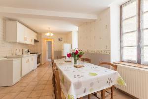 eine Küche mit einem Tisch und einer Blumenvase darauf in der Unterkunft Maison Picard in Saint-Romain