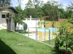 a fence in a yard with a swimming pool at Hotel Arbom in Mogi-Guaçu