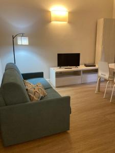 sala de estar con sofá y TV en Nonno 'Drea guest house, en Castiglione della Pescaia