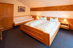 a bedroom with a large wooden bed and a bench at Haus im Winkl in Bad Hindelang