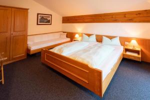 ein Schlafzimmer mit einem großen Holzbett und einer Bank in der Unterkunft Haus im Winkl in Bad Hindelang