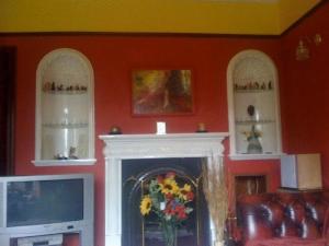 uma sala de estar com lareira e televisão em Newcourt B & B em Llantwit Major