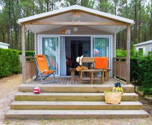 a wooden gazebo with a table and a chair at Camping Village Le Vieux Port***** in Messanges