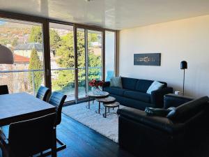 Panorama Apartment في ترييستي: غرفة معيشة مع أريكة زرقاء وطاولة