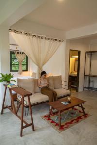 a woman sitting on a couch in a living room at Big Tree Boutique Hotel in Ko Tao