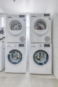four washing machines and a washer and dryer in a room at Limehome Garching bei München in Garching bei München
