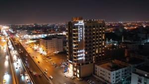 a night view of a city with a tall building at Iridium 70 Hotel in Jeddah