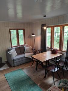 uma sala de estar com um sofá e uma mesa em Old Finnish lakeside cottage with sauna em Oulu