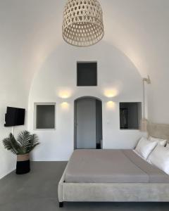 a bedroom with a large bed and a chandelier at Arco Bianco Suites in Akrotiri