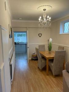 a dining room with a table and chairs and a chandelier at Silver Stag Properties,Comfy House in Coalville in Hugglescote
