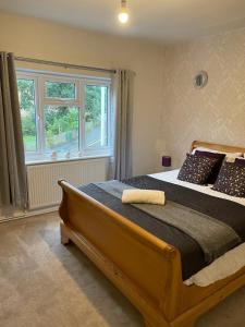 a bedroom with a large bed with a large window at Silver Stag Properties,Comfy House in Coalville in Hugglescote