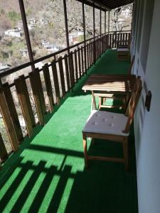 d'un balcon avec deux tables et un banc. dans l'établissement GUEST HOUSE ELENA, à Kosovo