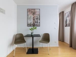 een eetkamer met een tafel en 2 stoelen bij limehome Passau Bahnhofstraße in Passau