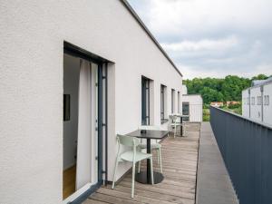 un balcone con tavoli e sedie in un edificio di limehome Passau Bahnhofstraße a Passavia