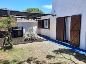 un patio con una mesa y una silla junto a una casa en Luna Azul, en Piriápolis