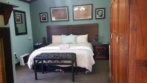 een slaapkamer met een bed met een houten hoofdeinde bij Izimbali Lodge and Restaurant in Ermelo
