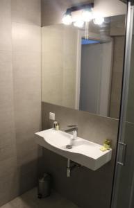 a bathroom with a white sink and a mirror at Albizja Hotel in Szczytno