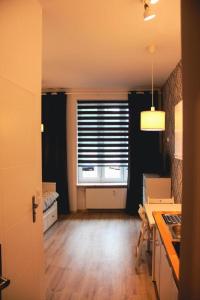 a kitchen with a white counter top and wooden floors at Apartament Kattowitz in Katowice