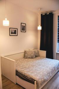 a bedroom with a bed and a lamp on the wall at Apartament Kattowitz in Katowice