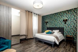 ein Schlafzimmer mit einem Bett und einer blau-grünen Wand in der Unterkunft The Originals Boutique, Hôtel La Baie de Morlaix in Carantec