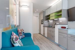 ein Wohnzimmer mit einer blauen Couch in einer Küche in der Unterkunft The Brucklyn Apartments in Erlangen