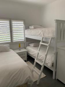 a bedroom with two bunk beds and a ladder at Ballito Durban north Aloha in Ballito