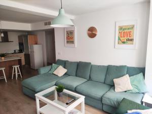 a living room with a blue couch and a table at CARTAGENAFLATS, Apartamentos Anfiteatro Romano 2B in Cartagena