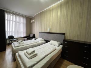 um quarto de hotel com duas camas e uma cadeira em The apartments em Kiev