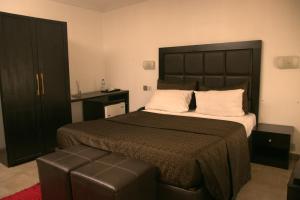 una camera da letto con un letto grande con testiera nera di Angel Hotel a Lagos