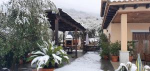 a building with a covered patio in the snow at Casa rural la huerta de los nogales in Herrera del Duque