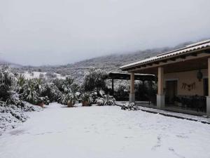 une cour recouverte de neige à côté d'une maison dans l'établissement Casa rural la huerta de los nogales, à Herrera del Duque