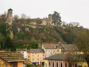 un castillo en la cima de una colina con casas en Gîte des Halles - gitesdesbalcons-com, en Crémieu