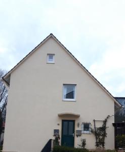 a white house with a green door at Ferienwohnung an der Kurklinik in Bad Driburg