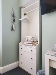 a bedroom with a white dresser and a closet at Ivy Bank Guest House, Tenby in Tenby