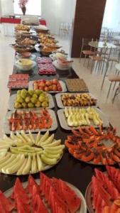 uma longa mesa cheia de diferentes tipos de alimentos em Hotel Golden Dolphin com café da manhã! Piscinas 24h em Caldas Novas