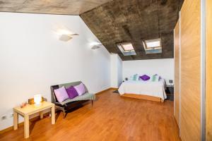 a bedroom with a bed and a couch and a table at Bocage Loft (Setúbal downtown) in Setúbal +12 photos