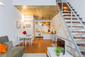 a living room and kitchen with a spiral staircase at Bocage Loft (Setúbal downtown) in Setúbal