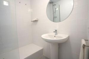 uma casa de banho branca com um lavatório e um espelho em Hostal Hera em Barcelona