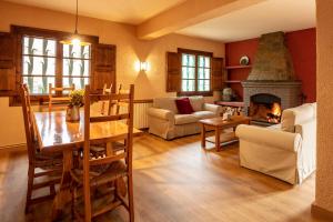 a living room with a table and a fireplace at El Xalet del Priorat in Escaladei