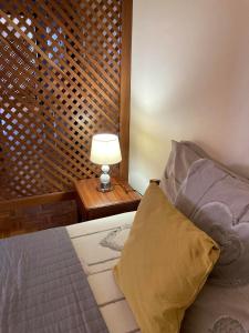 a bedroom with a bed and a lamp on a table at Pendora Appartements in Mindelo